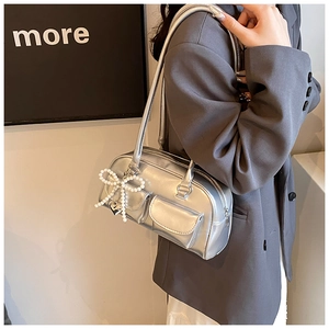 Detailed shot of metallic silver PU shoulder bag with dual pockets and pearl bow charm