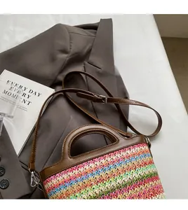 Detail of colorful woven straw bag with adjustable brown leather strap and wave pattern