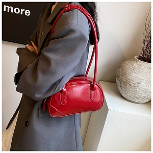 Close-up of a red patent leather bowling bag paired with a grey oversized blazer