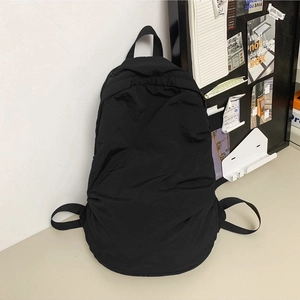 Minimalist black nylon backpack with pleated texture for summer casual style
