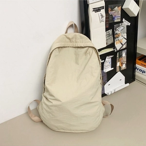 Minimalist beige nylon backpack for women featuring a drawstring closure and webbed straps
