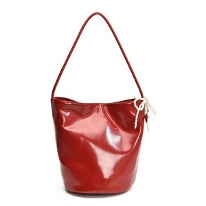 Red glossy PU leather bucket bag with pearl bow charm and minimalist shoulder strap