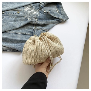 Chic beige woven straw bucket bag with gold chain strap and drawstring closure