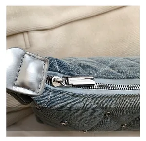 Detail showing blue denim quilting fabric with silver zipper and rhinestone rivet accents