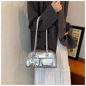 Close-up of metallic silver PU shoulder bag featuring functional pockets and pearl bow charm