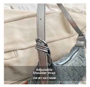 Adjustable leather shoulder strap on a quilted denim bag with silver rivet details