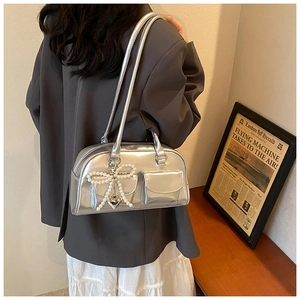 Close-up of metallic silver PU shoulder bag featuring pearl bow and heart charm details
