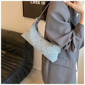 Detail of light blue denim crossbody bag with diamond stitching and shiny rhinestones