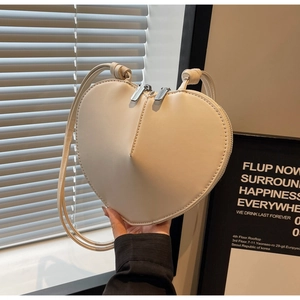 Dettaglio della borsa a tracolla a forma di cuore bianco crema con doppia cerniera