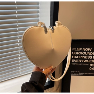 Dettaglio della borsa in pelle bianca a forma di cuore con cerniere in argento