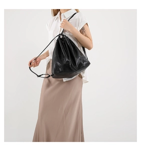 Detailed view of women's black PU leather bucket backpack with geometric embossed pattern