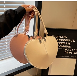 Dettaglio di borse a forma di cuore in pelle PU rosa e beige con manico a nodo