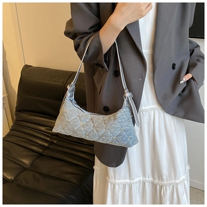 Detail of light blue denim hobo bag with quilted rhinestones on a female model
