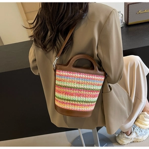 Detail showing colorful striped woven bucket bag with brown leather strap and trim
