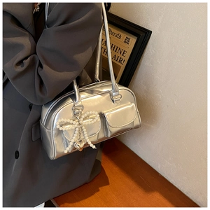 Detail shot of a silver metallic PU Boston bag with dual pockets and pearl bow charm