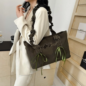 Sac fourre-tout en toile olive avec nœuds en soie et bandoulière plissée sur mannequin