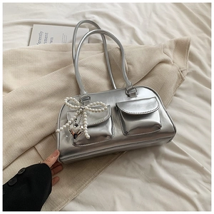Silver metallic PU leather shoulder bag with pearl bow and heart pendant on a soft background