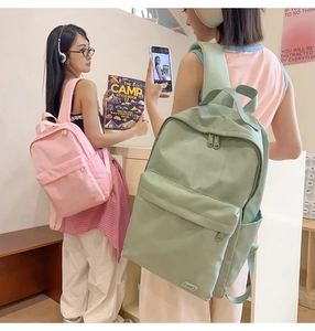 Modelle asiatiche con zaini alla moda in nylon rosa e verde in un ambiente di vita moderna
