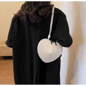 Borsa a spalla bianca a forma di cuore su blazer nero, stile minimalista da donna