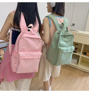 Vista dettagliata degli zaini alla moda in nylon rosa e verde chiaro con multitasche