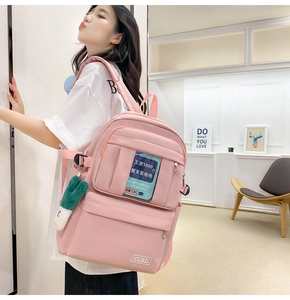 Détail d'un sac à dos en nylon rose avec pendentif cactus et poches multifonctions