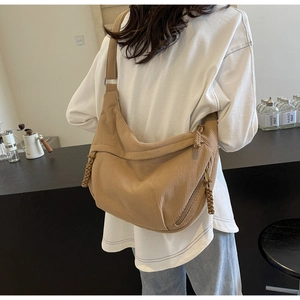Detail of camel corduroy hobo bag showing fabric texture and braided zipper pull
