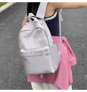 Vista dettagliata di uno zaino in nylon grigio chiaro con tasche multiple per il pendolare