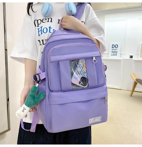 Détail du sac à dos en nylon violet avec poche transparente et breloque peluche