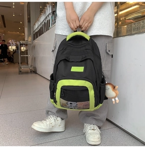 Detail of nylon bag featuring neon green contrast stripes and cute plush toast charm