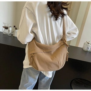 Close-up of khaki corduroy crescent bag with vertical texture and woven zipper detail