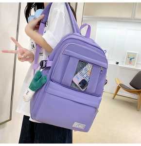Détail du sac à dos en nylon lilas avec poche PVC transparente et breloque en peluche verte