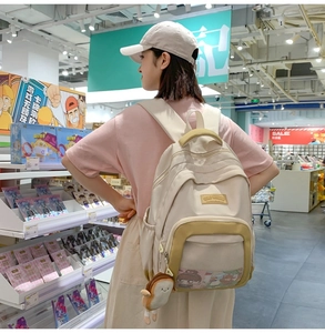 Detail of minimalist nylon mesh crossbody bag featuring a clear front pocket and plush charm