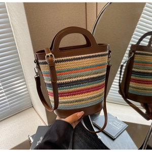 Colorful striped straw bucket bag with dark brown leather straps and silver hardware