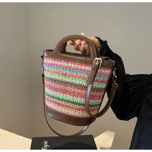 Chic multi-color straw bucket bag with brown leather trim and adjustable crossbody strap