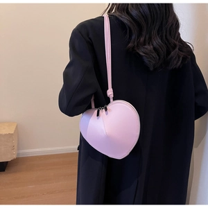 Vista posteriore di una modella con borsa a tracolla rosa a forma di cuore in stile chic