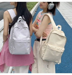 Dettaglio di zaini in nylon lilla e crema con scomparti spaziosi e tasche frontali chiuse