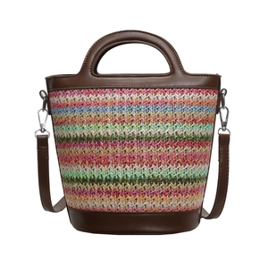 Colorful striped straw bucket bag with brown leather handles and adjustable shoulder strap