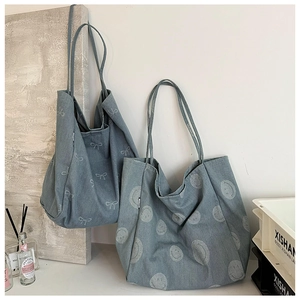 Detail of vintage blue denim tote bags with bow and smiley prints in a lifestyle setting