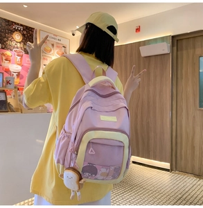 Rear view of a pink and yellow nylon backpack with mesh pocket and toast plush charm