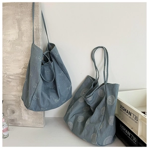 Close-up of denim tote bags with bow and smiley face prints and durable long straps