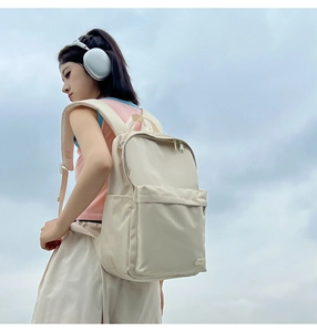 Dettagli dello zaino in nylon beige con tasche multiple e spallacci imbottiti