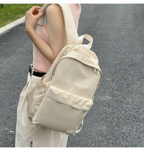 Vista laterale dello zaino in nylon crema con tessuto impermeabile e grande capacità