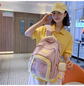 Detail of pink and yellow nylon backpack with mesh pocket and cute plush bread pendant