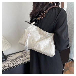 Detail of white satin handbag with bamboo bird jacquard and wooden bead handle