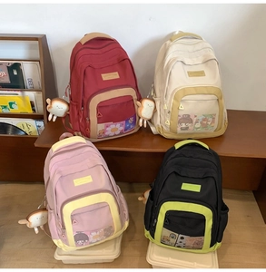 Detail showing colorful nylon crossbody bags with mesh pockets and plush charms