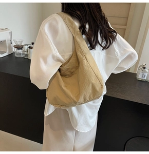 Bolso de hombro grande en nailon caqui puesto en modelo que muestra la caída y el tejido suave