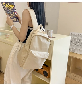 Zaino in nylon crema indossato mostra scomparti spaziosi e spallacci larghi comodi