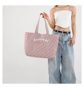 Detail of red striped canvas tote bag showing summer print and durable handle
