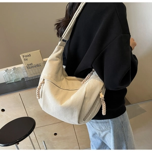 Detail van beige corduroy halve maan tas met dikke geweven ritssluiting voor vrouwen