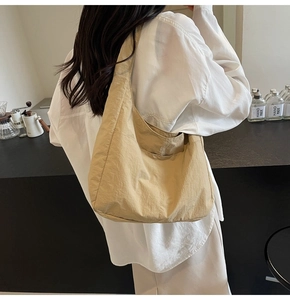 Detalle del bolso hobo de nailon beige con textura natural y correa de hombro integrada